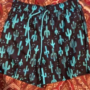 Black and blue shorts with cactus graphics design.
